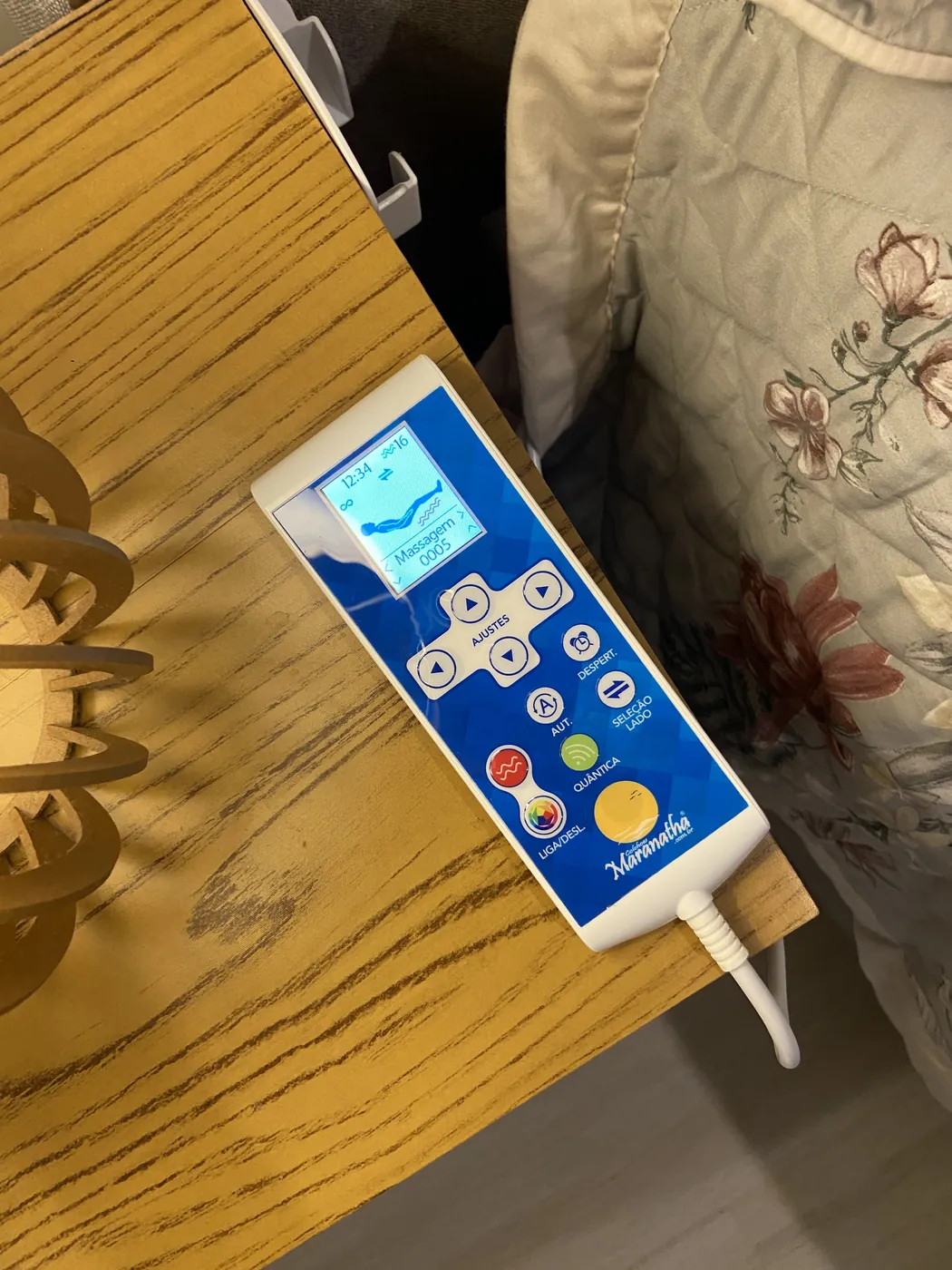 Controle de massagem Maranatha ao lado da cama