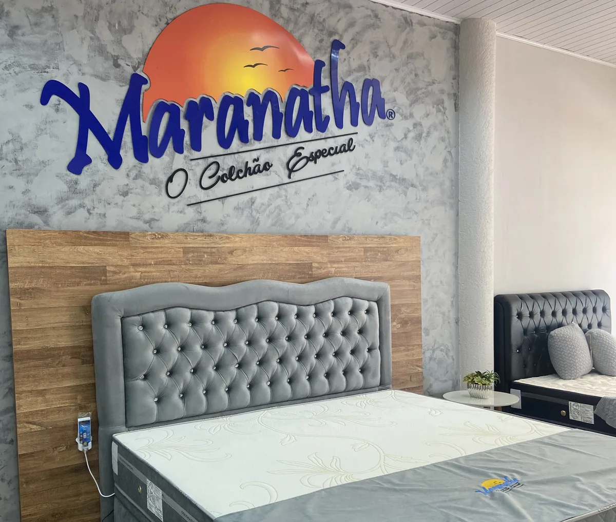 Colchão Maranatha exposto diante da marca da empresa